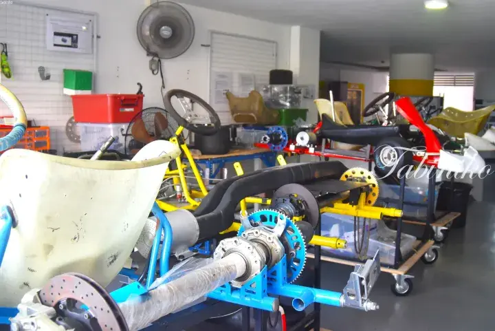 Go-kart chassis frames and spare parts in a workshop, showcasing the mechanical assembly process.