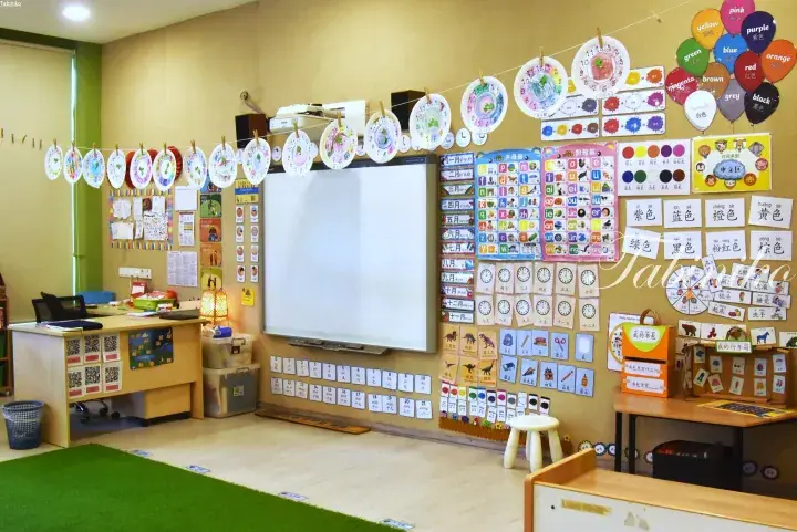 Colorful classroom wall with Chinese learning charts, paper clocks, and student artwork.