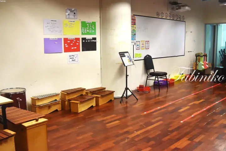 Music classroom with xylophones, a whiteboard, and belt charts on the wall.