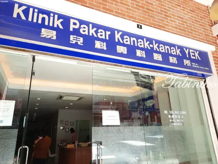 Exterior view of Klinik Pakar Kanak-kanak YEK, a pediatric specialist clinic with a blue sign and glass entrance.