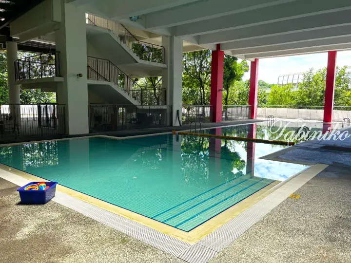 Covered swimming pool with turquoise tiles, red pillars, and a blue toy bin at a Malaysia residential property.