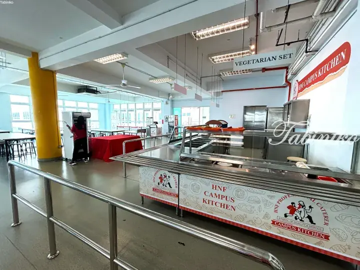 HNF Campus Kitchen food counter with vegetarian set signage in a bright university cafeteria.