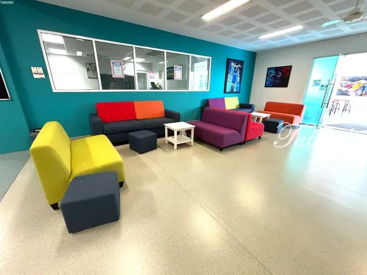 Colorful student lounge with vibrant sofas and teal walls at a Malaysia campus.