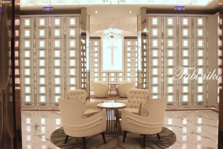 Luxury chapel interior with cream armchairs, glowing wall niches, and a central cross.