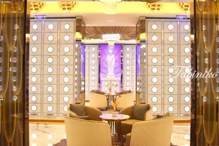 Luxury interior of a modern columbarium featuring illuminated niches and a serene Buddha statue.