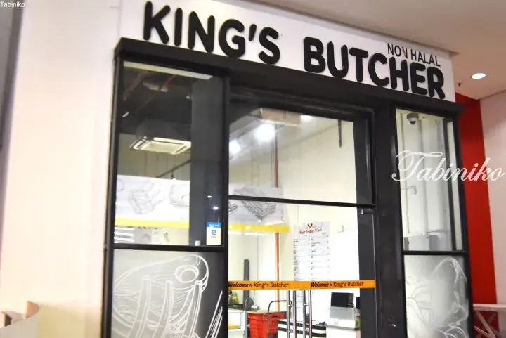 King&rsquo;s Butcher storefront in a Malaysian mall, featuring a black and white sign with &lsquo;NON HALAL&rsquo; text and glass entrance doors.
