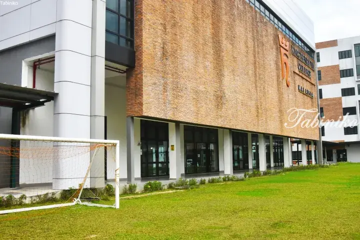 King Henry VIII College Malaysia building exterior with brick facade and soccer goal on the lawn