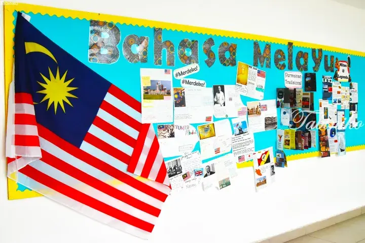 Malaysian school bulletin board featuring the national flag, &lsquo;Bahasa Melayu&rsquo; title, and student projects on history and culture.