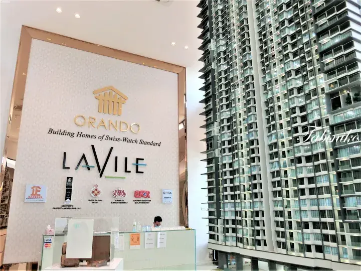 Orlando LaVile sales gallery interior showing the reception desk and a large architectural model of the high-rise condominium.