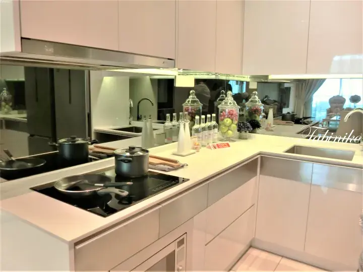 Modern kitchen with white cabinets, induction cooktop, and fruit jars in a serviced apartment.