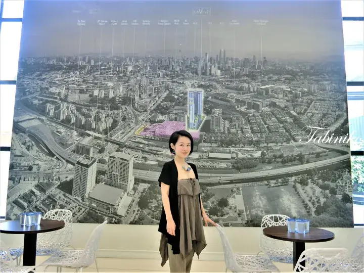 Woman posing in front of a large map showcasing the LaVile property location and nearby Kuala Lumpur landmarks.