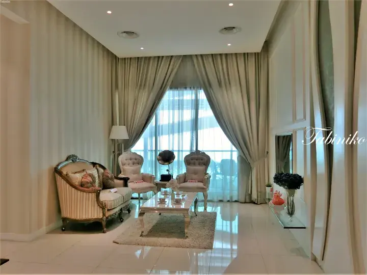Elegant living room with vintage furniture, cream curtains, and a gramophone in a Malaysian property.