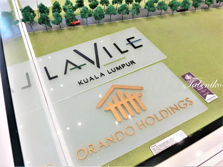 Architectural model display for LaVile Kuala Lumpur by Orando Holdings, featuring landscaping details and award plaques.