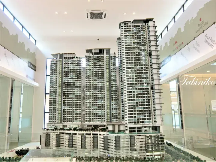 Architectural model of La Ville Kuala Lumpur towers with transit line maps on display walls.