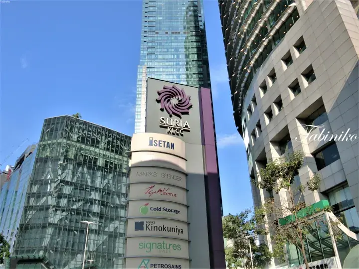 苏丽亚KLCC购物中心指示牌，列出伊势丹和TGV影院等租户，背景可见双子塔。