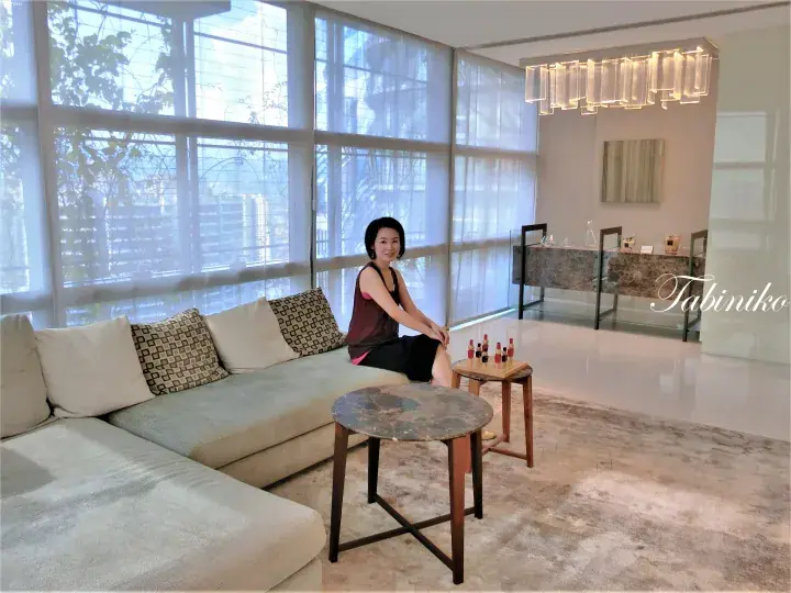 坐在拥有大窗户和设计师家具的现代豪华公寓沙发上的女性。