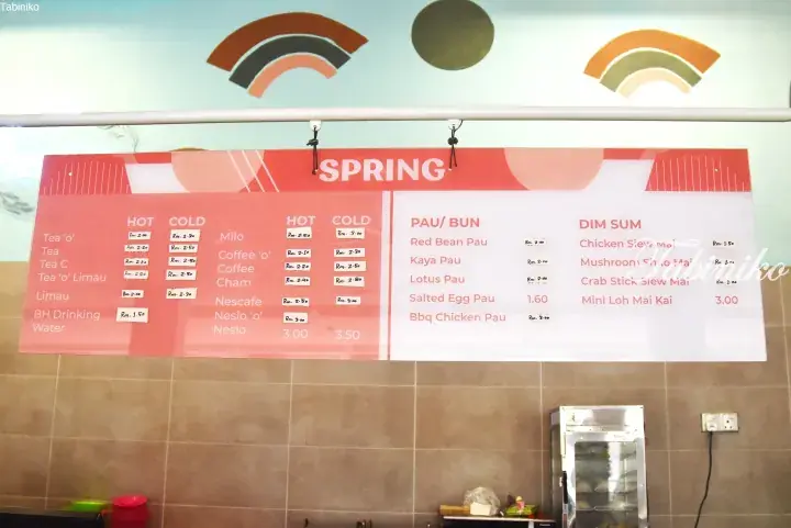 Menu board at Spring restaurant displaying prices for hot and cold drinks, buns, and dim sum items.