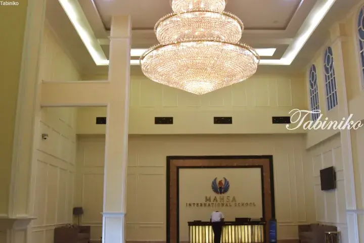 Grand lobby of Mahsa International School featuring a large crystal chandelier and reception desk.