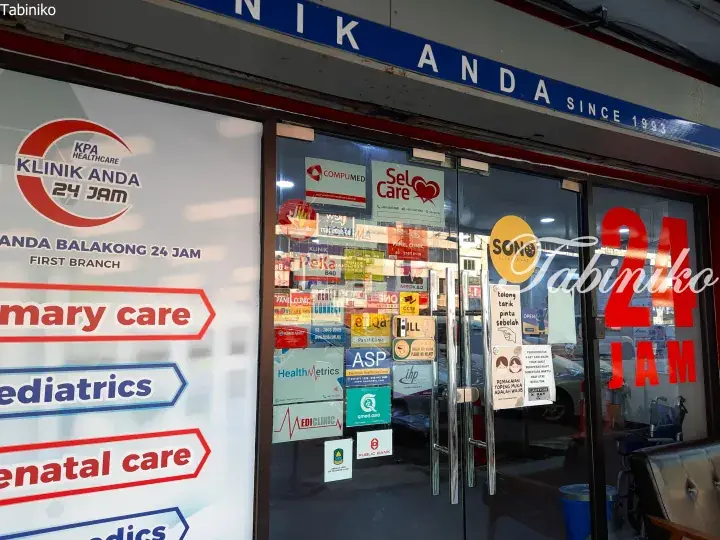 Klinik Anda Balakong entrance displaying 24-hour service, primary care, pediatrics, and various insurance panel stickers.