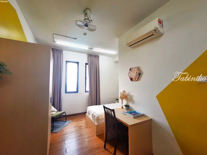 Bright bedroom with wooden flooring, single bed, desk, and air conditioning in a Malaysia property.