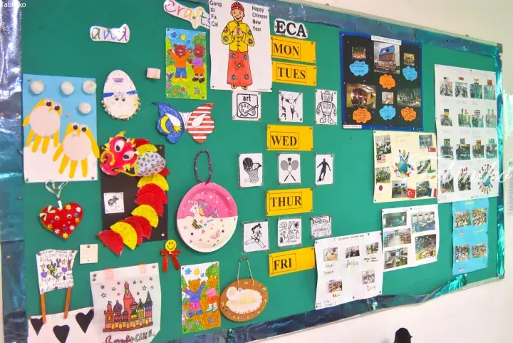 Classroom bulletin board displaying student crafts, Chinese New Year decorations, and an ECA schedule for Monday to Friday.