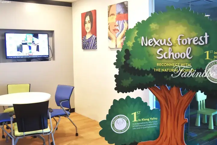Nexus Forest School interior featuring a large tree display with ‘Reconnect with the Natural World’ slogan and a seating area.