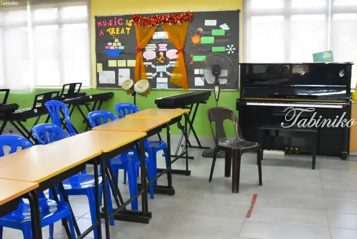 Music classroom with Kawai piano, keyboards, and colorful bulletin board.