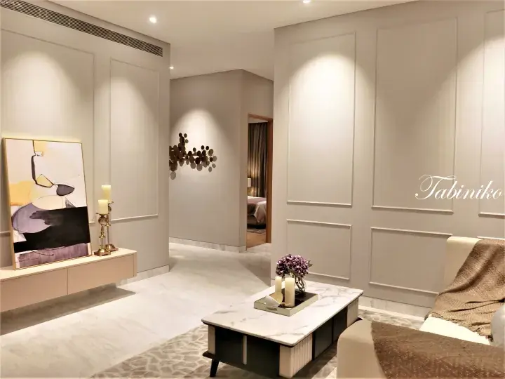 Modern luxury living room with marble flooring, abstract art, and elegant wall paneling in a Malaysian property.
