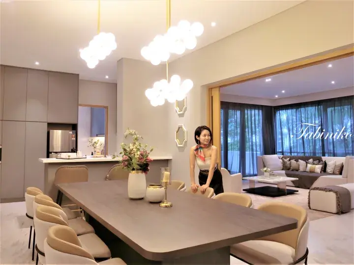 Modern dining room with a long wooden table and cloud pendant lights in a luxury property.