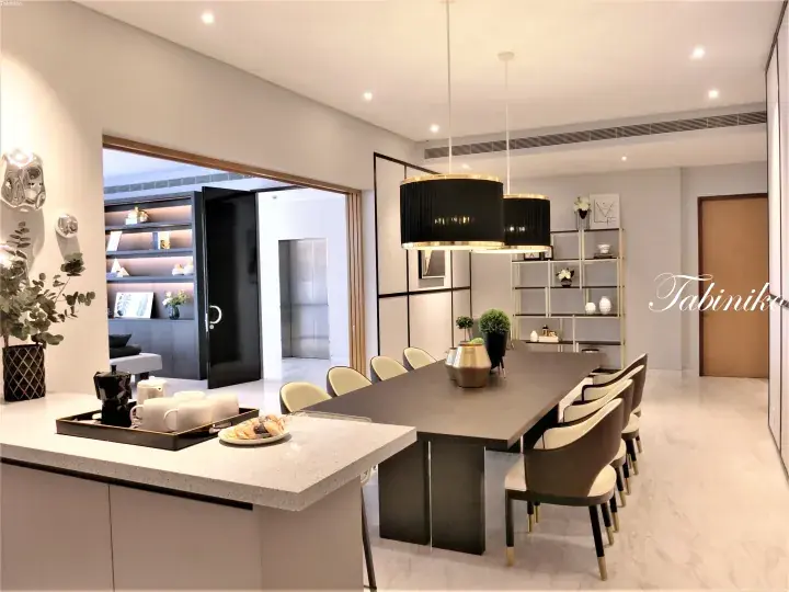 Modern dining room with a long dark table, elegant chairs, and black pendant lights in a luxury property.