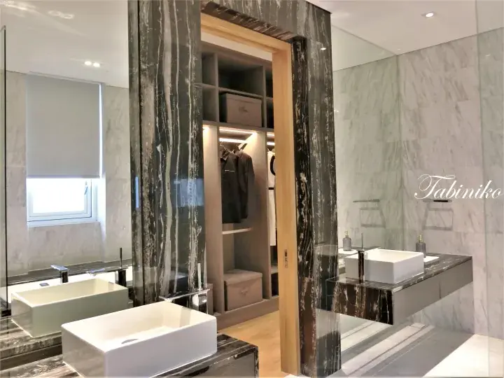 Luxury bathroom with marble walls, dual sinks, and walk-in closet in a high-end Malaysian property.