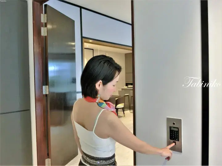 Woman entering a modern apartment using a keypad lock on the door.