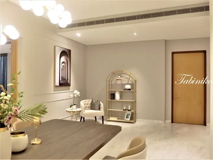 Modern dining room with wooden table, gold shelving unit, and elegant decor in a luxury Malaysian property.