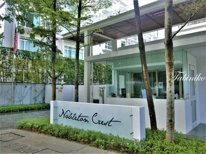 Nobleton Crest condominium entrance sign with modern guardhouse and Malaysian flag