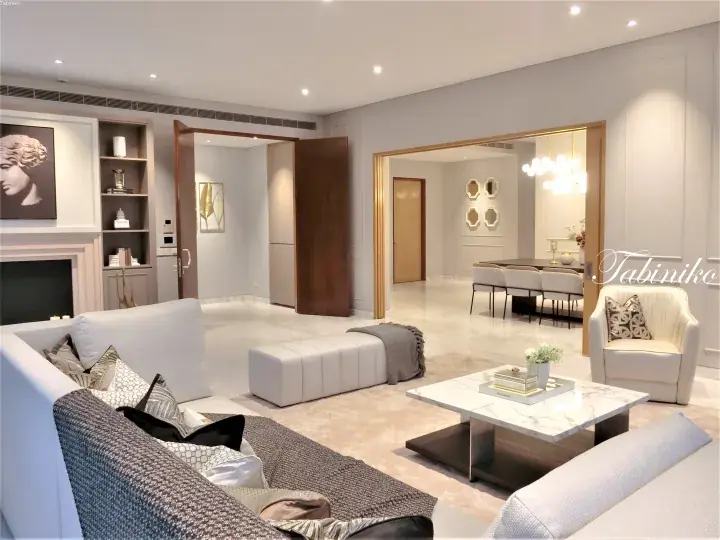Modern luxury living room with white sofa, marble coffee table, and open dining area in a high-end Malaysian property.