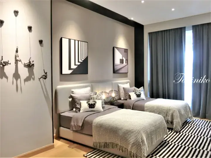 Modern twin bedroom with grey beds, dog pillows, and climbing wall art in a luxury Malaysian property.