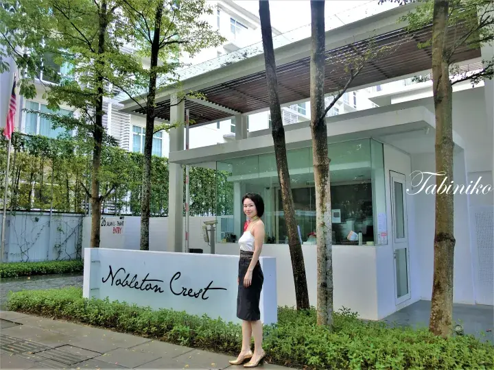 Woman posing at the entrance of Nobleton Crest condominium, 26 Jalan U-Thant, Kuala Lumpur.