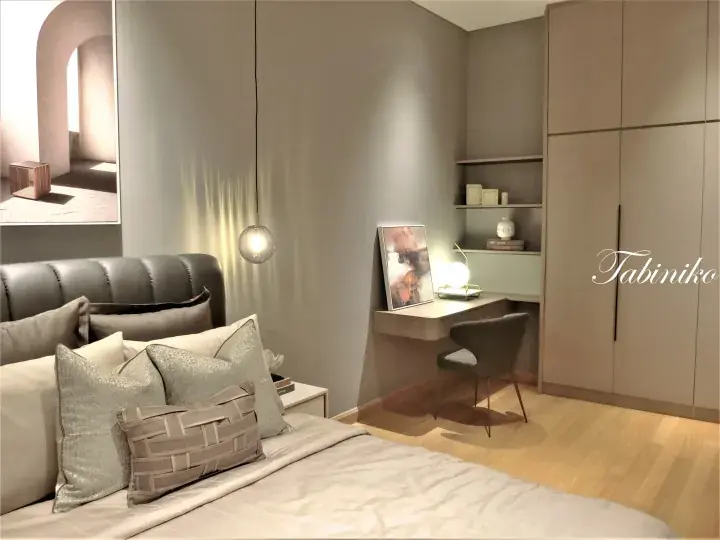 Modern bedroom with a grey leather bed, built-in desk, and wardrobe in a stylish property.