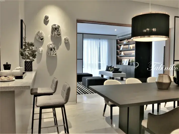Modern dining area with a dark table, bar stools, and silver wall art in a luxury apartment.