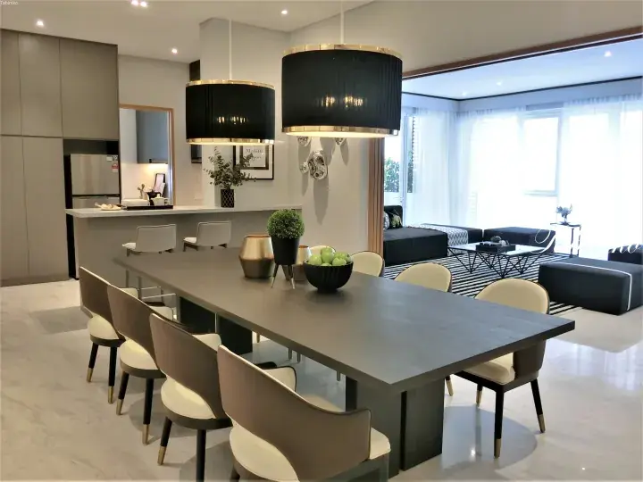 Modern dining table with grey chairs and black pendant lights in a luxury apartment living area