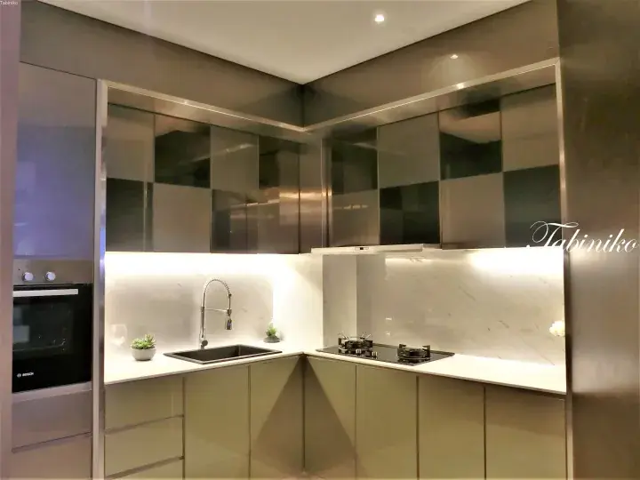 Modern kitchen with sleek stainless steel cabinets, marble backsplash, and built-in Bosch oven.