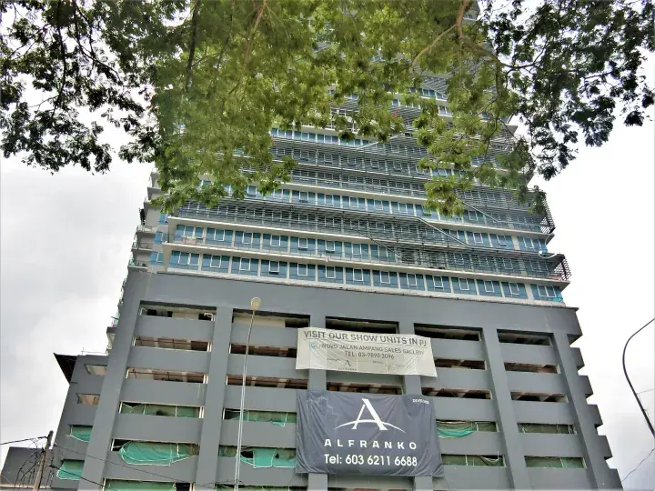 Alfranko apartment building under renovation in Malaysia with banners advertising Novo Jalan Ampang sales gallery.