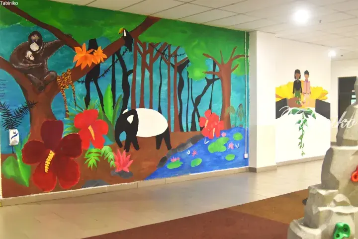 Colorful jungle mural with orangutans and tapirs adorns a hallway wall in a Malaysian property.