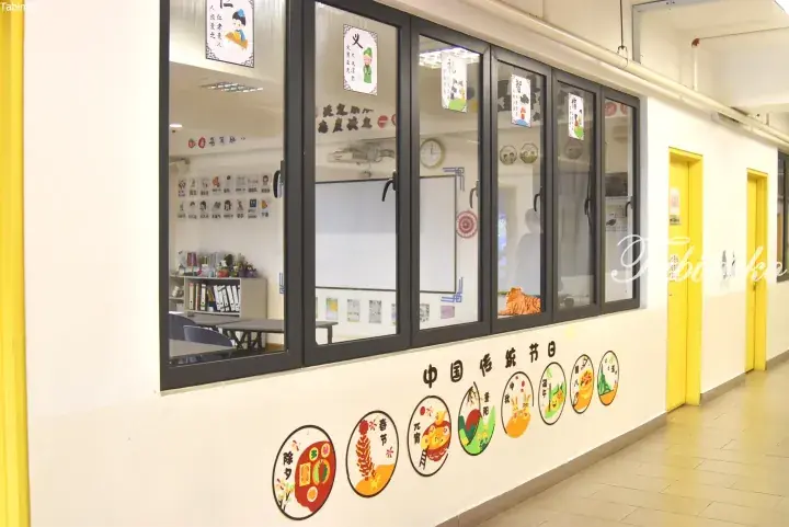 Bright school corridor with yellow doors and wall decorations illustrating traditional Chinese festivals.