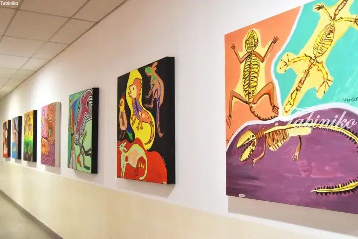 Colorful abstract animal paintings displayed in a modern hallway.
