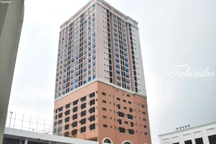 Tall pink residential building with blue windows and a distinctive orange base in Malaysia