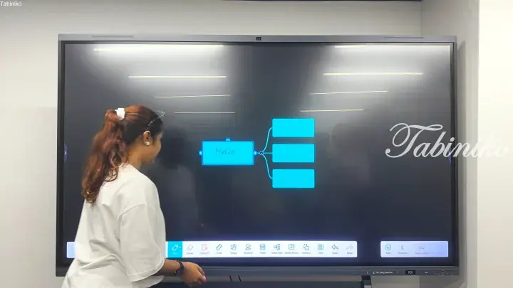 Woman using interactive smart board to create a mind map diagram in a modern office setting.