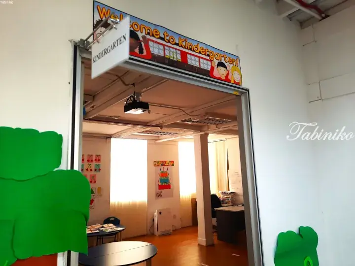 Entrance to a kindergarten classroom with a colorful banner, projector, and child-friendly decorations.