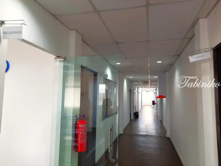 Bright hallway in a Malaysia educational facility with glass-walled classrooms labeled English Room and Y10 Sci.