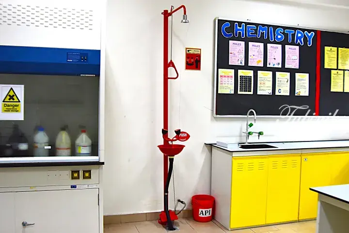 Chemistry lab with safety shower, fume hood, and bulletin board.